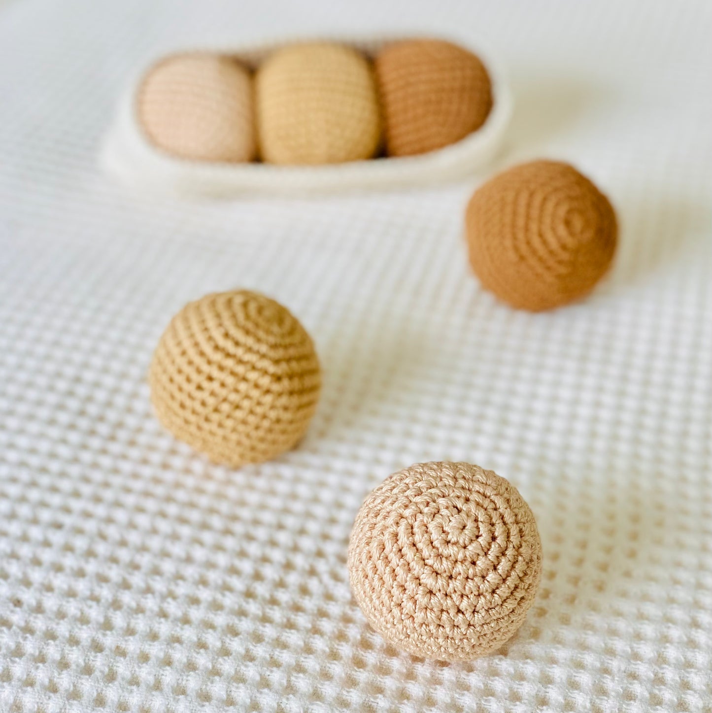 A set of handmade beige and brown textured balls, made from cotton thread and designed to fit in a crochet pod