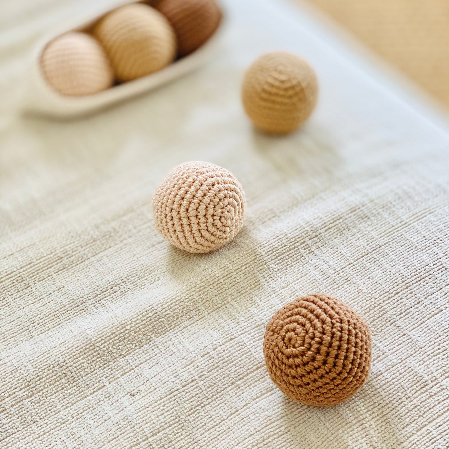 A set of handmade beige and brown textured balls, made from cotton thread and designed to fit in a crochet pod