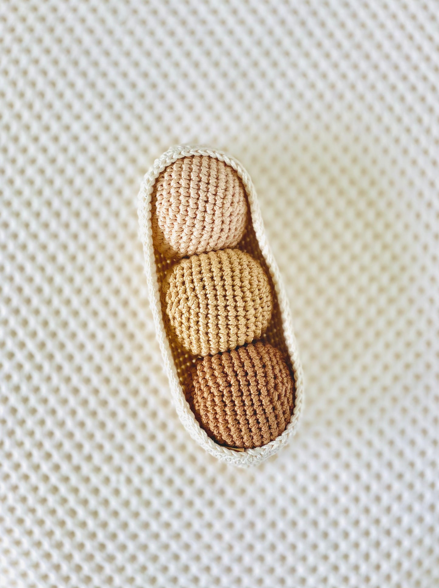 A set of cotton handmade beige and brown textured balls fitting perfectly into a crochet pod