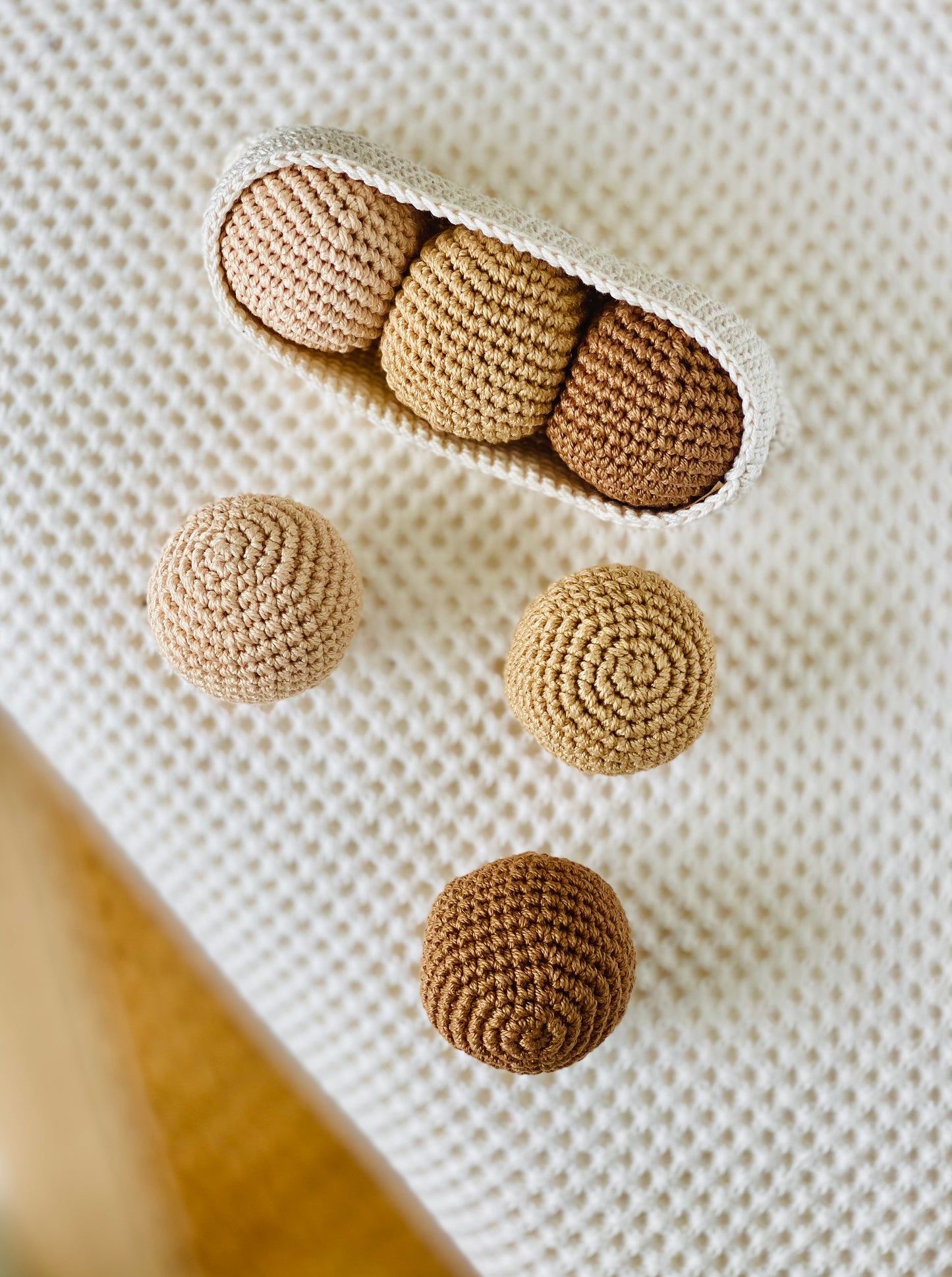 A set of handmade beige and brown textured balls, made from cotton thread and designed to fit in a crochet pod