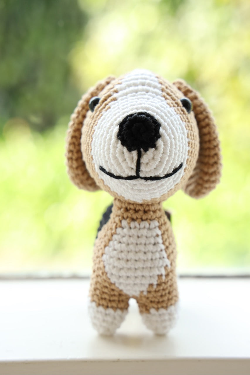 The front view of a crocheted beagle toy with floppy ears 