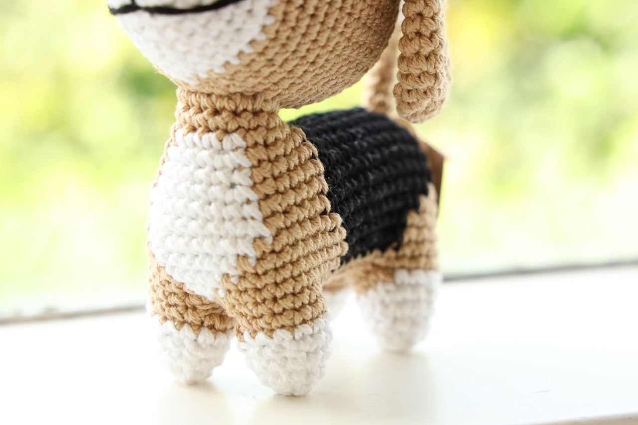 Close up view of a crocheted beagle toy with floppy ears